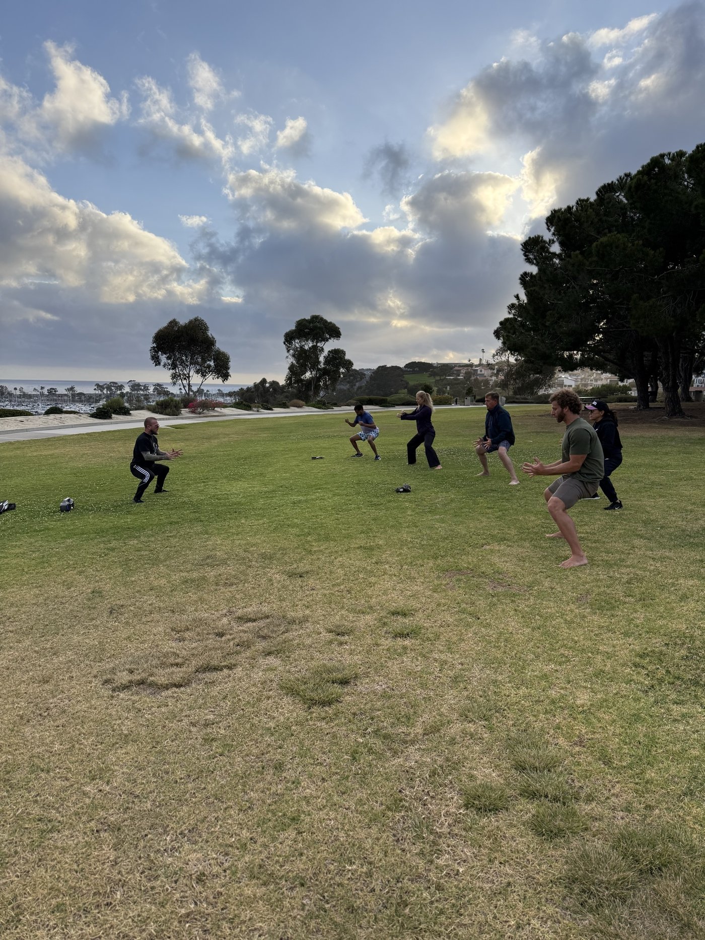 KCJK group breathwork session with dramatic sunset sky over the harbor