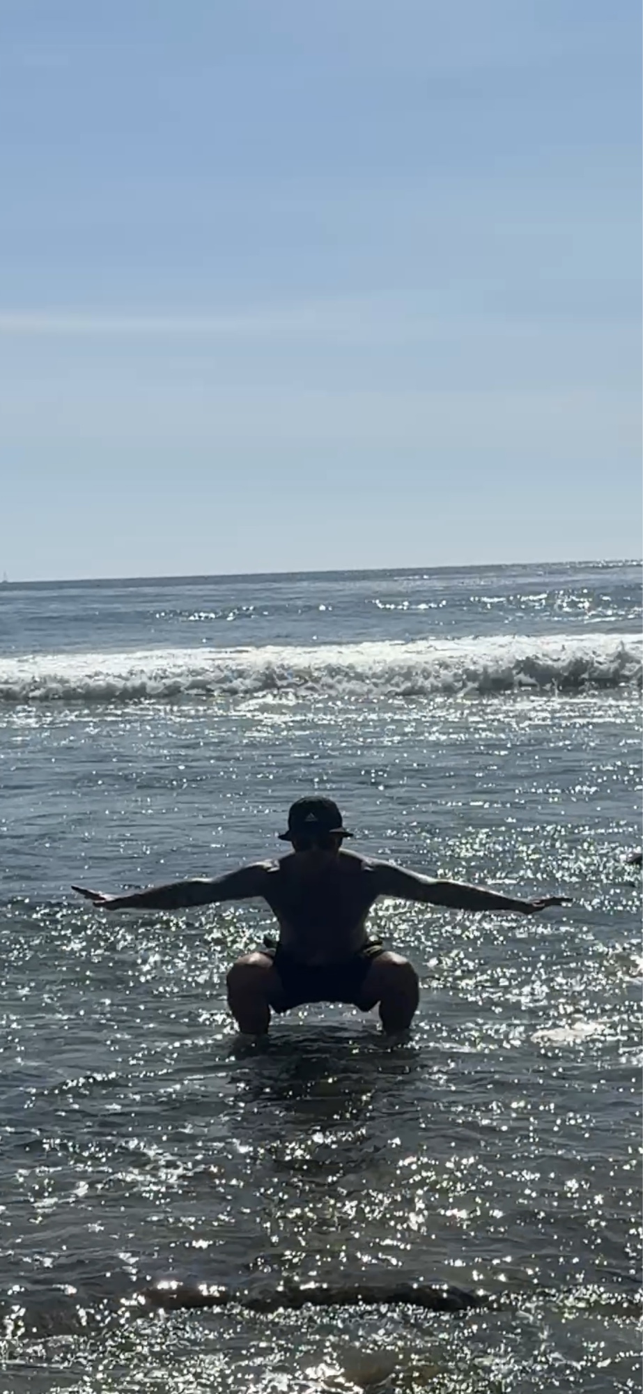 Shaun Anderson silhouetted practicing Korean Tai Chi at Laguna Beach, low squat stance